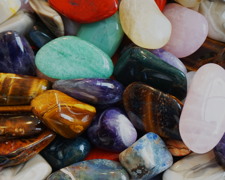 Assorted colorful stones and crystals on a textured surface